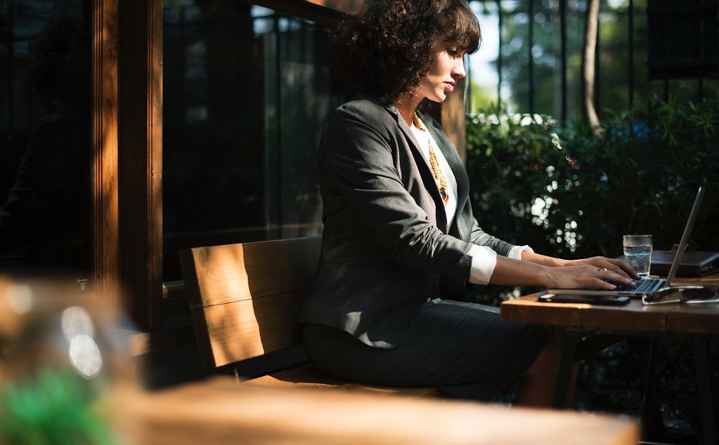 Businesswoman Sitting Outside with Laptop   Credit to https://bestpicko.com/